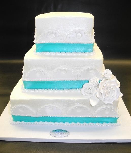 White Icing Wedding Cake with Fondant Decorations and Blue Ribbon 