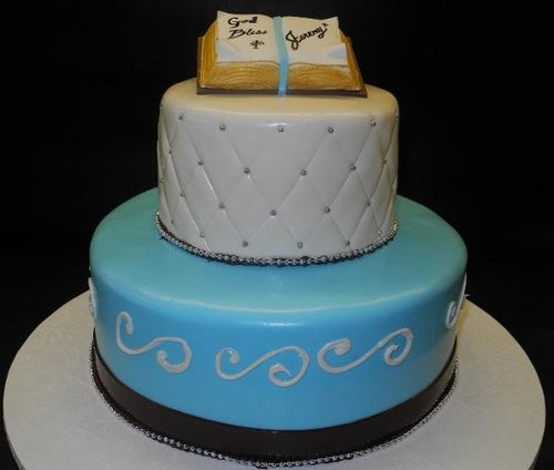 Religious blue, white, and brown cake with edible bible on top
