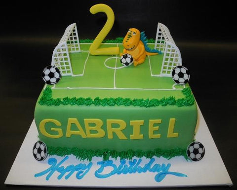 Soccer field fondant cake with edible fondant dinosaur 